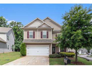 Charming two-story home with a well-manicured front yard and a two-car garage at 345 Lara Ln, Mcdonough, GA 30253