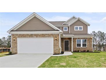 Charming two-story home featuring a brick facade, attached two-car garage and a well-manicured lawn at 1651 Tide Mill Rd, Cumming, GA 30040