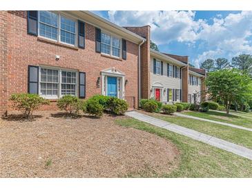 Charming brick townhomes featuring well-maintained lawns and colorful front doors at 4101 Dunwoody Club Dr # 49, Atlanta, GA 30350