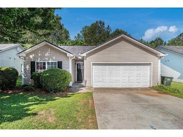 Charming single-Gathering home featuring a two-car garage and a well-manicured front lawn at 9188 Jefferson Village Sw Dr, Covington, GA 30014