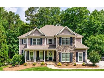 Charming two-story home featuring a stone facade and well-manicured front yard, surrounded by mature trees at 255 Ashmere Ct, Tyrone, GA 30290