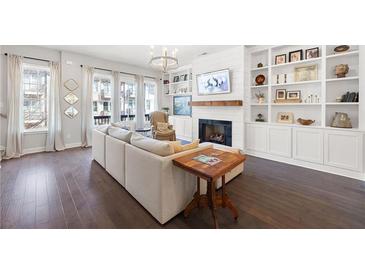 Bright living room with hardwood floors, built-in shelves, fireplace, and large windows providing natural light at 217 Napa Dr, Woodstock, GA 30188