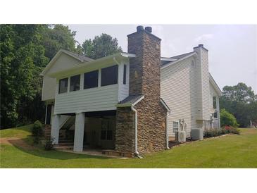 Charming home exterior featuring stone accents and a spacious yard with lush landscaping at 2477 Briar Valley Way, Dacula, GA 30019