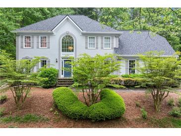Charming two-story home with a well manicured landscaped front yard and classic architectural details at 4433 Windsor Oaks Cir, Marietta, GA 30066