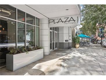 Exterior of the building featuring a covered entrance, modern architecture and outdoor seating area for residents and guests at 950 W Peachtree Nw St # 1214, Atlanta, GA 30309