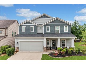 Beautiful two-story home featuring a manicured lawn and a two-car garage at 100 Grove View Rd, Woodstock, GA 30189
