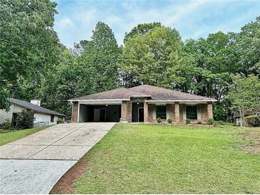 Charming single-story brick home with a spacious front yard and covered parking at 1341 Beeblossom Trl, Lawrenceville, GA 30044
