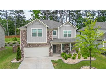 Charming two-story home with brick accents and a well-maintained landscaped front yard at 688 Saffron Blvd, Lawrenceville, GA 30045