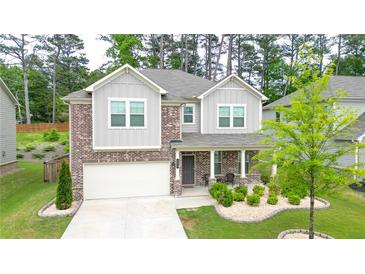 Charming two-story home featuring a brick facade, covered porch, and well-manicured front yard at 688 Saffron Blvd, Lawrenceville, GA 30045