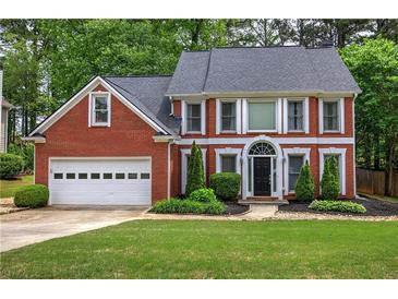 Charming brick home with a well-manicured lawn, two-car garage, and mature trees at 3186 Sail Winds Nw Dr, Acworth, GA 30101