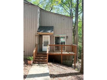 Cozy home featuring a wood deck entrance, wood siding, and a well-maintained walkway at 5846 Par Four Ct, Lithonia, GA 30038