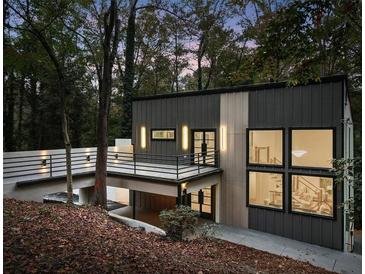 Modern home exterior featuring a cantilevered balcony, standing seam metal, and woodland setting at 1153 Dawn View Nw Ln, Atlanta, GA 30327