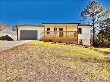 Charming single-story home with a gray garage door, wooden porch, and a well-maintained front yard at 2535 Impala Dr, Cumming, GA 30041