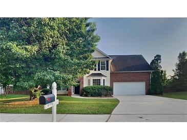 Two-story brick home with a two-car garage, lawn and landscaping at 6170 Winston Trce, Mcdonough, GA 30252