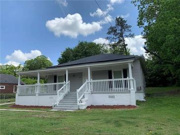 Charming home featuring a welcoming front porch and landscaped yard at 1234 Triple Hill Dr, Macon, GA 30084