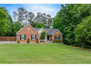 Charming brick home featuring a well-manicured lawn and inviting front entrance at 3982 Ivory Gables Pl, Buford, GA 30519
