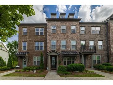 Charming brick townhome features a landscaped front yard and inviting curb appeal at 10143 Windalier Way, Roswell, GA 30076
