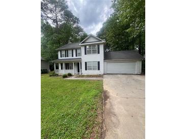 Charming two-story home features a well-manicured lawn and attached two car garage at 9866 Point View Dr, Jonesboro, GA 30238