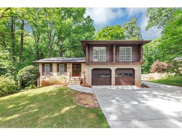 Charming two-story home with a two-car garage, beautiful brickwork, and a well-manicured front yard at 563 Navarre Dr, Stone Mountain, GA 30087