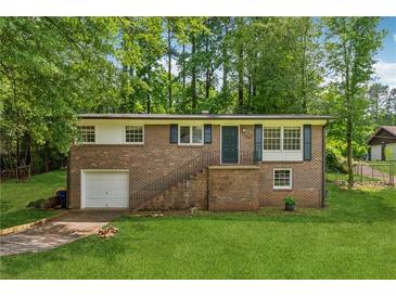 Charming brick home with a well-maintained lawn, inviting entrance, and one-car garage on a sunny day at 2015 Twelve Oaks Nw Cir, Kennesaw, GA 30144