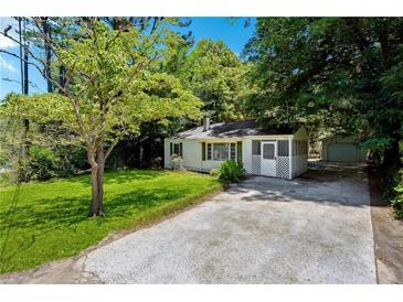 Charming home featuring a well-manicured lawn, mature trees, and a welcoming screened front porch at 4742 West Dr, Forest Park, GA 30297