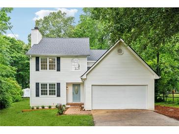 Charming two-story home with a well-manicured lawn, white siding, and an attached two-car garage at 2040 Sunrise Cir, Cumming, GA 30040