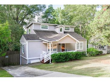 Charming home featuring a welcoming front porch, well-maintained lawn, and mature trees enhancing curb appeal at 1390 Almont Sw Dr, Atlanta, GA 30310