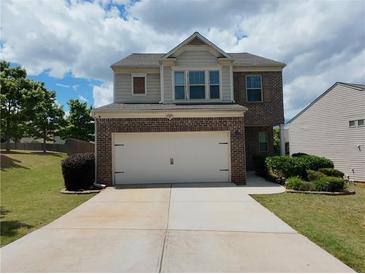 Two-story home with brick facade and attached two-car garage featuring a well-manicured lawn at 1369 Star Water Dr, Lawrenceville, GA 30045