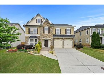 Charming two-story home with stone accents, two-car garage, and beautifully landscaped front yard at 4195 Settlers Grove Rd, Cumming, GA 30028