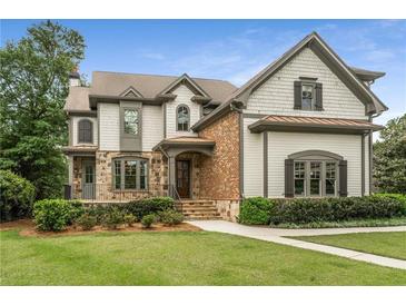 Charming two-story home with manicured lawn, stone accents, and a welcoming front porch at 4823 Layfield Dr, Dunwoody, GA 30338