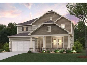 Charming two-story home featuring stone accents, a covered porch, and a two-car garage at 670 Redhead Way (Lot 23), Grayson, GA 30017