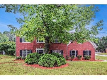 Charming red brick home with lush front yard and mature shade tree at 602 Jules Crest Ct, Lawrenceville, GA 30045