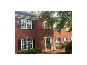 Traditional red brick home featuring a classic front door and multi-pane windows with black shutters at 602 Jules Crest Ct, Lawrenceville, GA 30045