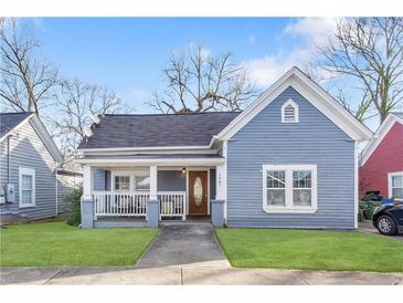 Charming blue one-story home featuring a welcoming front porch and well-maintained lawn at 1087 Longley Nw Ave, Atlanta, GA 30318