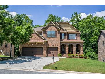 Beautiful brick two-story home featuring an attached two car garage and manicured front yard at 1185 Gallatin Way, Suwanee, GA 30024