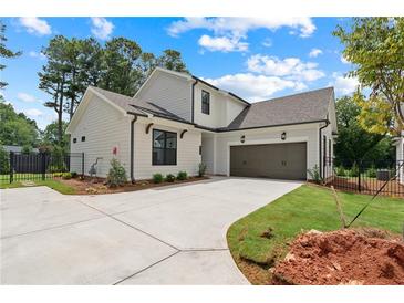 Charming home featuring a modern white exterior, two-car garage, and a spacious concrete driveway at 527 Pearl St, Cumming, GA 30040