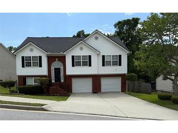 Charming two-story home with brick and white siding, two car garage, and well-maintained landscaping at 995 Chimney Trace Way, Lawrenceville, GA 30045