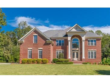 Elegant red brick home with a manicured lawn and symmetrical design, creating a welcoming and stately curb appeal at 270 Annelise Park Dr, Fayetteville, GA 30214