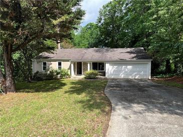 Charming single-story home with a two-car garage surrounded by lush greenery at 2705 Rhoanoke Dr, Duluth, GA 30096