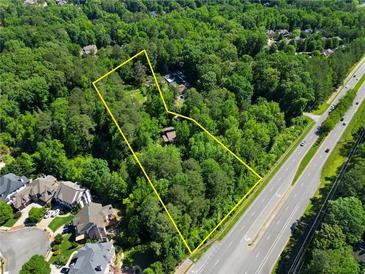 Aerial view of a large wooded lot with yellow boundary lines and road access at 605 Ga 120 Hwy, Roswell, GA 30075