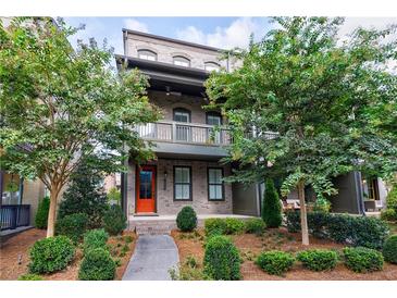 Charming two-story home with a brick facade, an inviting orange front door, and lush landscaping at 6645 Cortland Walk, Alpharetta, GA 30005