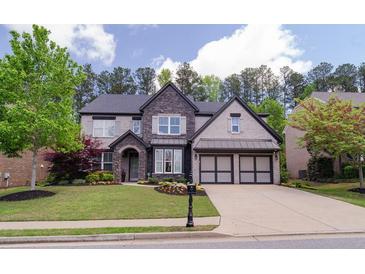 Charming two-story home with a manicured lawn, stone accents, and a two-car garage, creating a welcoming curb appeal at 2720 Garonne Way, Cumming, GA 30041