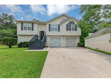 Charming split-level home featuring a two-car garage and freshly manicured lawn at 2880 Field Spring Dr, Lithonia, GA 30058