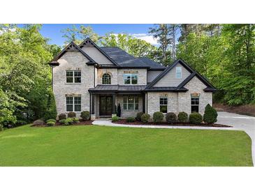Stunning two-story brick home features a lush lawn and manicured landscaping at 885 Old Peachtree Ne Rd, Lawrenceville, GA 30043
