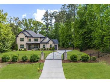 Beautiful brick two-story home featuring manicured landscaping and a gated driveway at 885 Old Peachtree Ne Rd, Lawrenceville, GA 30043
