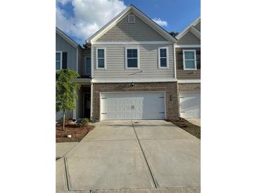 Two-story home featuring a brick facade and a two-car garage with a modern architectural design at 7621 Gray Pointe Dr, Lithonia, GA 30058