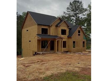 Unfinished two-story house showing its basic structure and dark roof against a backdrop of trees at 3312 Mill Forest Dr, Conyers, GA 30094