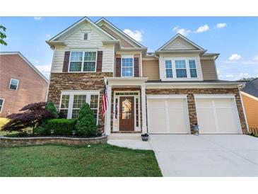 Charming two-story home showcasing a stone facade, a two-car garage, and manicured landscaping at 971 Reap Lane, Lawrenceville, GA 30043