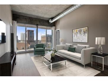 Stylish living room featuring hardwood floors, city views, and modern furniture at 943 Peachtree Ne St # 1010, Atlanta, GA 30309