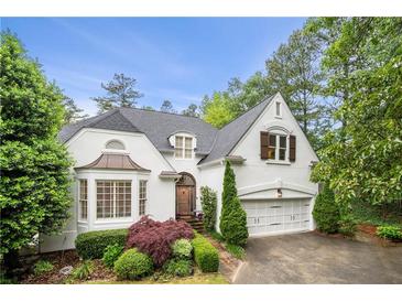 Charming two-story home featuring a landscaped yard, attached garage, and elegant architectural details at 4503 Woodhaven Ne, Marietta, GA 30067
